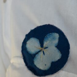 Broche imprimée cyanotype sur tissu brodé au fil d'or, réprésente une fleur d'hortensia