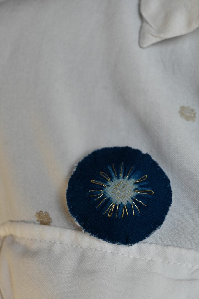 Broche imprimé en cyanotype sur tissu brodé au point de sable