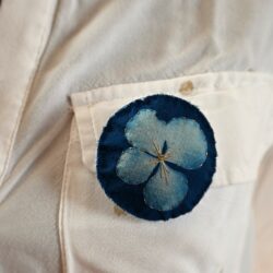 Broche impression cyanotype d'une fleur d'hortensia, brodée de fil d'or et perles dorées