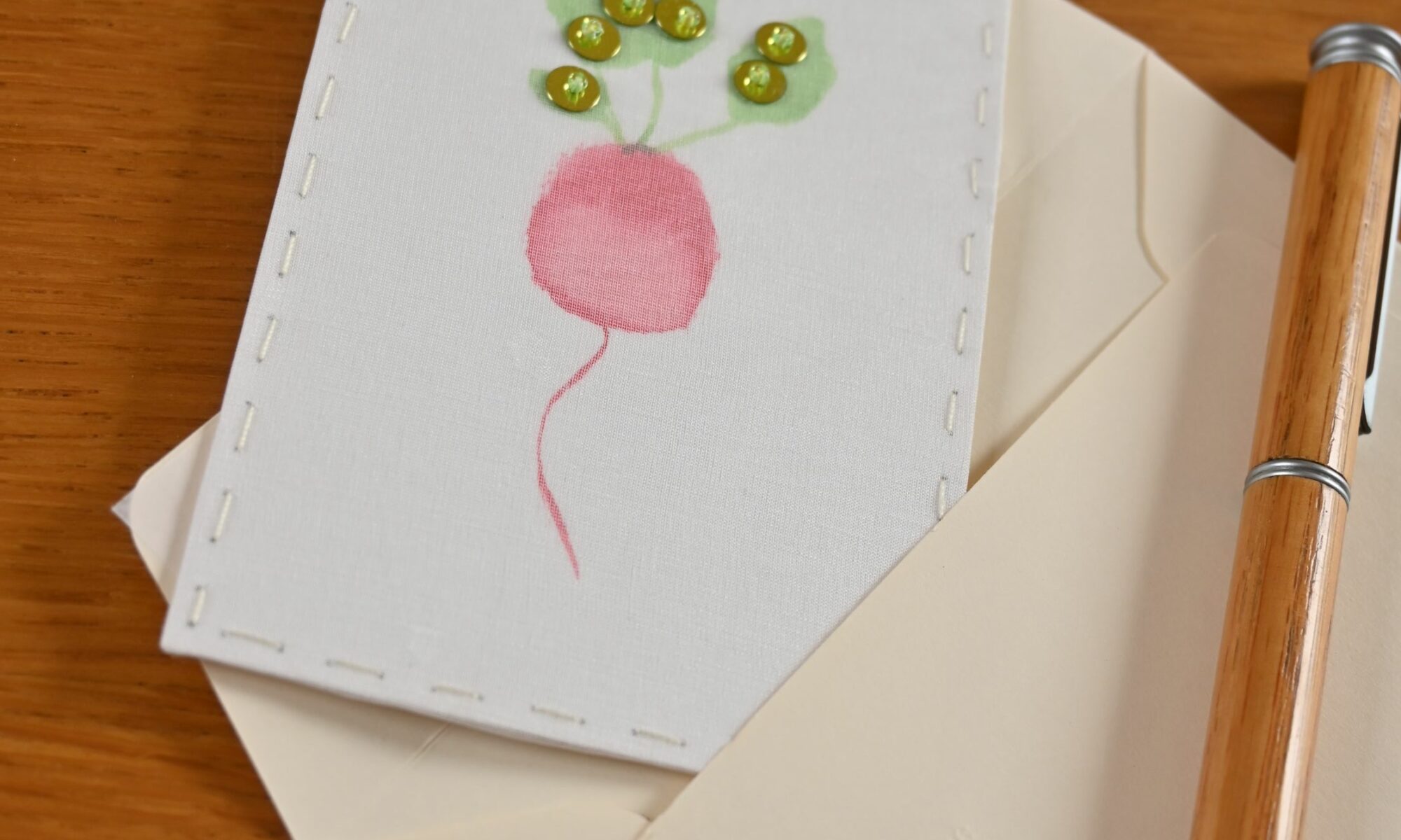 Broderie d'un radis sur organza et dessin d'aquarelle, paillettes et perles de rocaille vertes