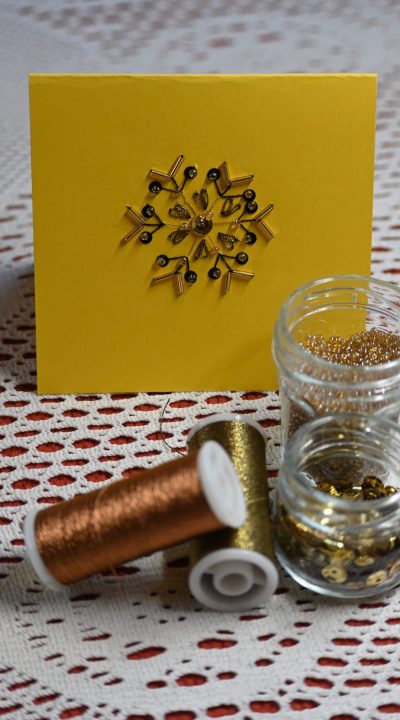 une carte brodée de perles avec du fil doré, des perles et des paillettes ou sequins