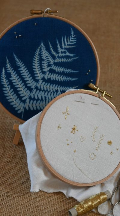 je vois un cyanotype sur tissu brodé au fil d'or, un cercle surlequel sont brodés différents points au fil métallisé or